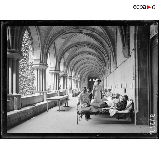 Asnières-sur-Oise. Ancienne abbaye de Royaumont. Hôpital écossais de 400 lits. Malades reposant dans leur lit dans une glaerie du cloître de l'abbaye. [légende d'origine]