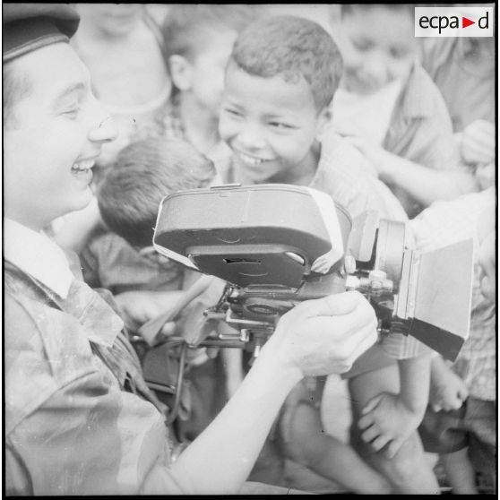 Portrait d'un cameraman du SCA d'Alger entouré d'enfants. [Description en cours]