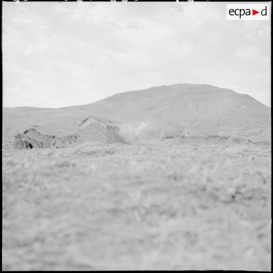 Dans une mechta, de la fumée sort d'une habitation.