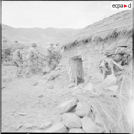 Des sodats se postent autour d'une habitation.