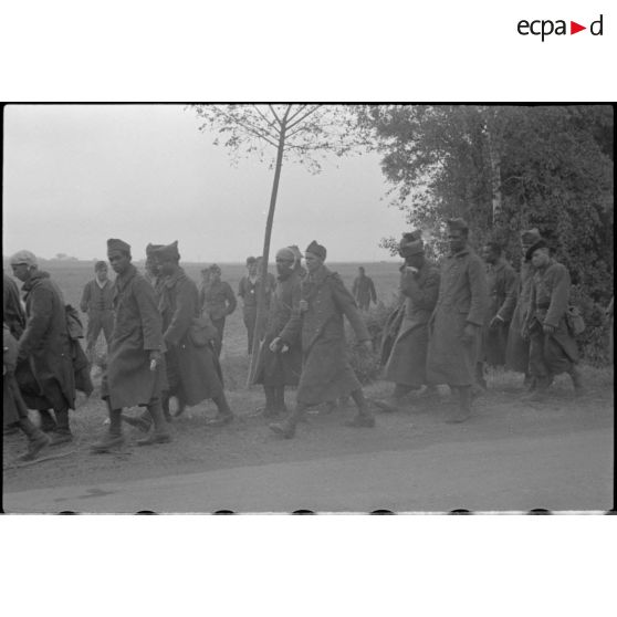 Une colonne de prisonniers avance péniblement.