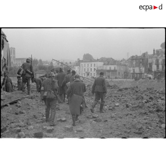 A Chateau-Thierry, des prisonniers français sont escortés par des fantassins armés de fusils Mauser 98 k.