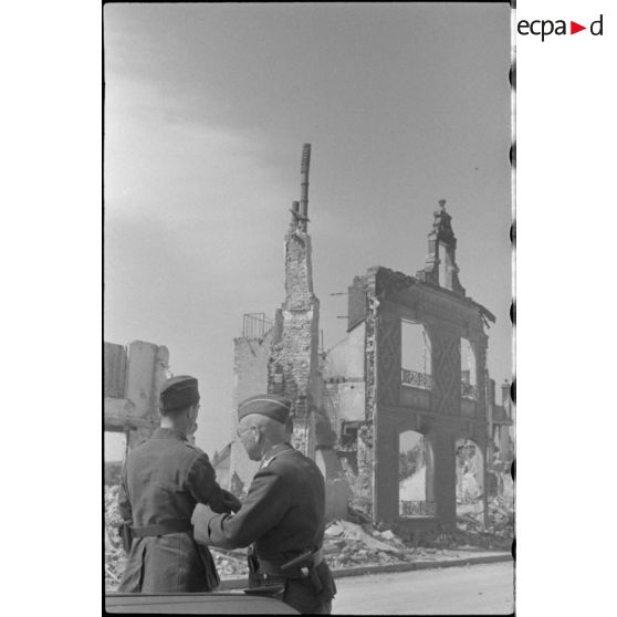 Des reporters de la Luftwaffe dans une rue dévastée de Rethel.