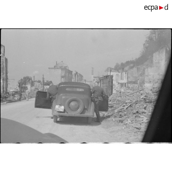 Des reporters de la Luftwaffe dans une rue dévastée de Rethel.