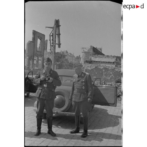 Des reporters de la Luftwaffe dans une rue dévastée de Rethel.