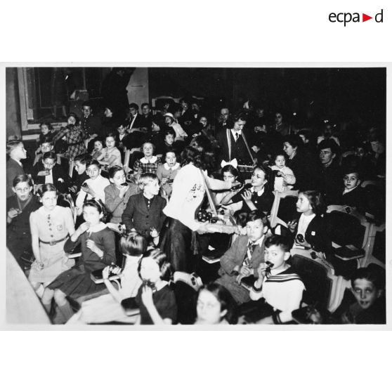 Des friandises sont distribuées aux enfants avant un spectacle.