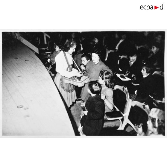 Des friandises sont distribuées aux enfants avant un spectacle.