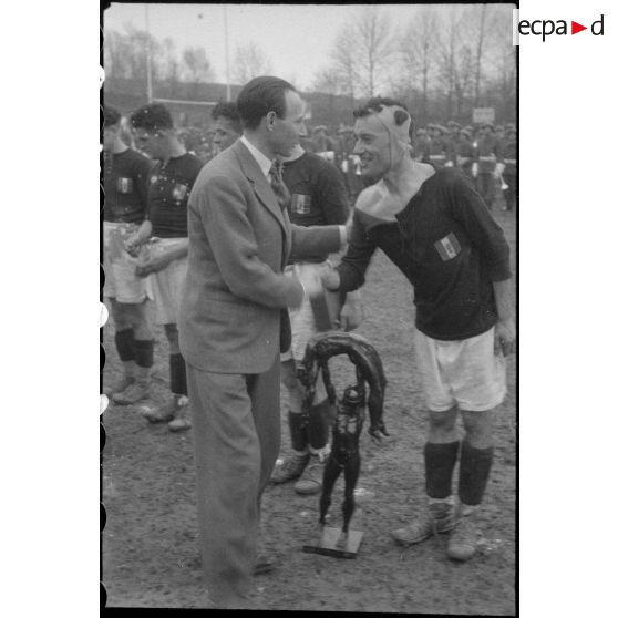 Remise de la coupe à l'équipe gagnante de la finale du championnat militaire de rugby.