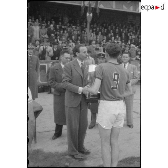 Remise de la coupe à l'équipe gagnante de la finale du championnat militaire de basket-ball.