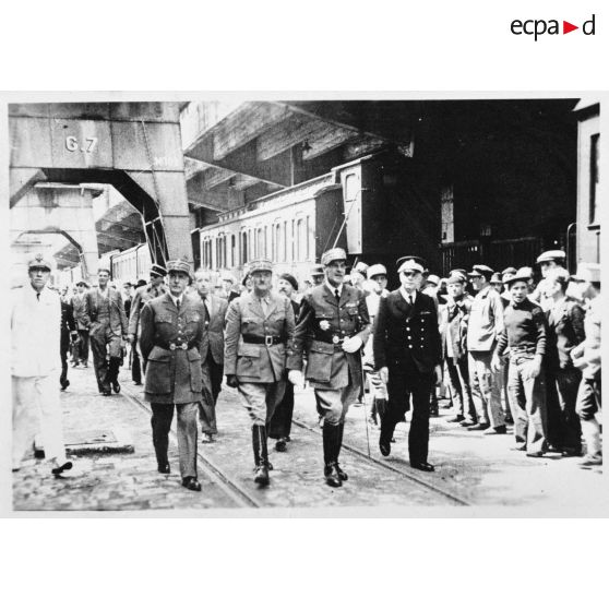 Les autorités civiles et miitaires arrivent sur un quai du port de Marseille pour accueillir les troupes rapatriées.