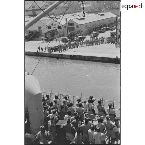 Des troupes de la 7e division d'infanterie australienne rendent les honneurs aux troupes vichystes au départ des navires.