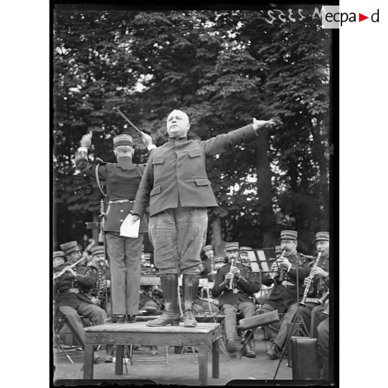 Le chanteur Alland de l'opéra comique chantant la Marseillaise lors de la fête nationale belge organisée dans les jardins du château de Versailles. [légende d'origine]