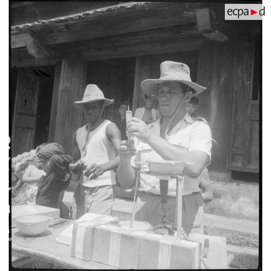 Le médecin-commandant chargé de la vaccination des villageois de Ha Hoï prépare son matériel.