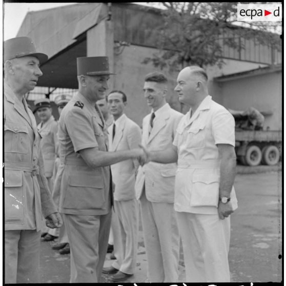 Le général Carpentier échange une poignée de main avec M. Lamdière, conseiller régional, sur l'aérodrome de Bach Maï.