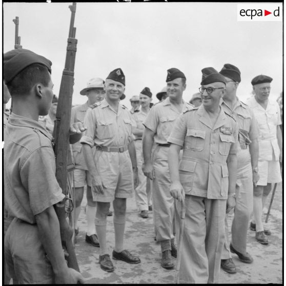 Le colonel Gambiez, commandant la zone delta-nord, inspecte le détachement d'honneur et le matériel du Génie ayant contribué à la construction du pont de Trinh Duc Ha.