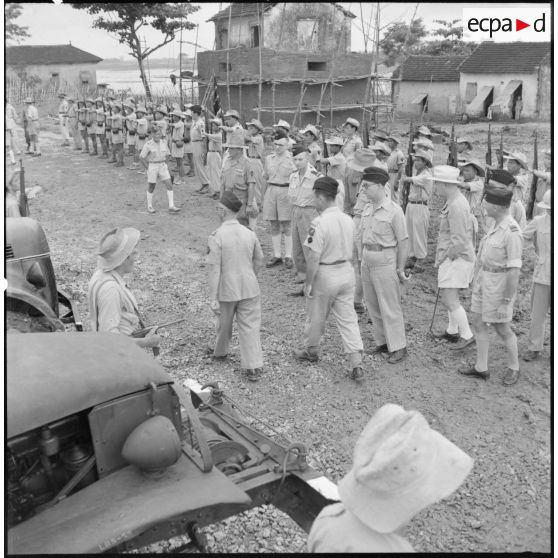 Le colonel Gambiez, commandant la zone delta-nord, inspecte le détachement d'honneur et le matériel du Génie ayant contribué à la construction du pont de Trinh Duc Ha.