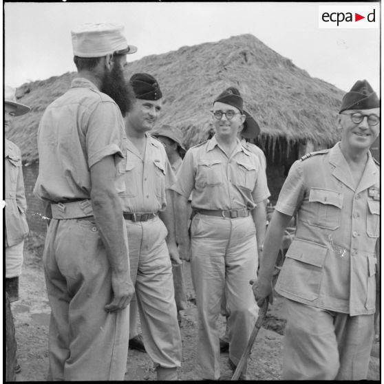Le colonel Gambiez, commandant la zone delta-nord, inspecte le détachement d'honneur et le matériel du Génie ayant contribué à la construction du pont de Trinh Duc Ha.