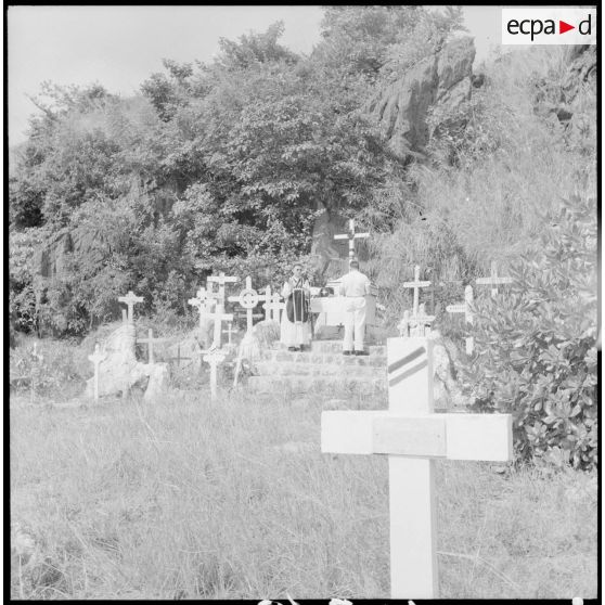 Un prêtre devant l'autel au cours d'une cérémonie militaire au cimetière marin de la baie d'Along.