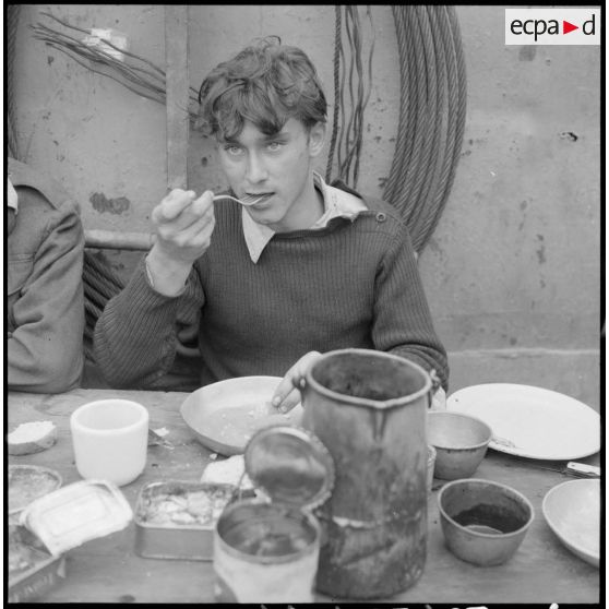 Portrait d'un marin prenant lors du repas à bord d'un chaland de débarquement navigant sur le fleuve Rouge au Tonkin.