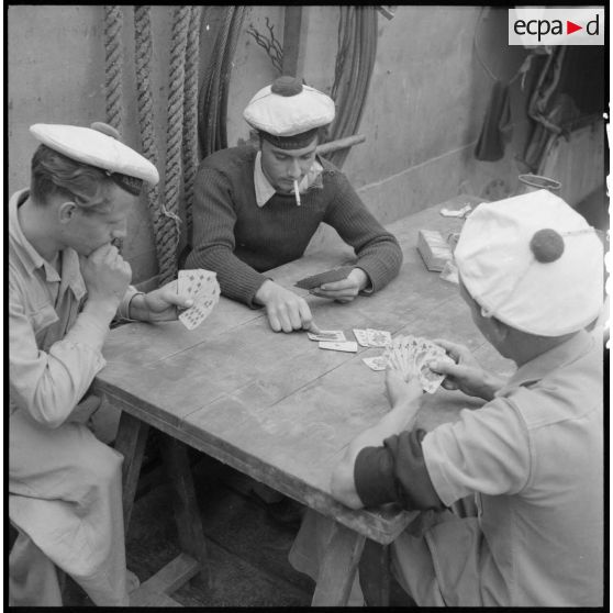 Partie de cartes entre des marins à bord d'un chaland de débarquement sur le fleuve Rouge au Tonkin.