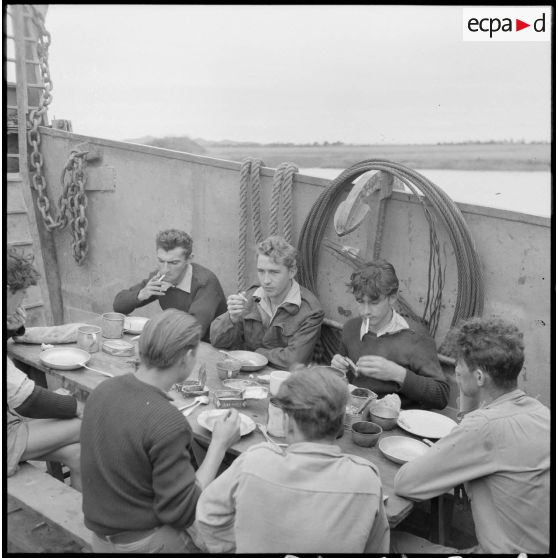 Des marins prenant leur repas à bord d'un chaland de débarquement navigant sur le fleuve Rouge au Tonkin.
