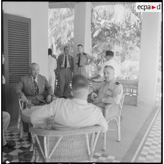 Le général Carpentier, commandant en chef en Indochine, s'entretient autour d'une table avec M. Deo Van Long, président de la fédération Thaï et M. Tersakissof, chef de province, au cours d'une visite à Laï Chau.