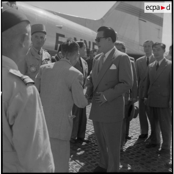 Accueil de Bao Daï, chef de l'état vietnamien, par diverses personnalités sur le terrain d'aviation d'Hanoï.