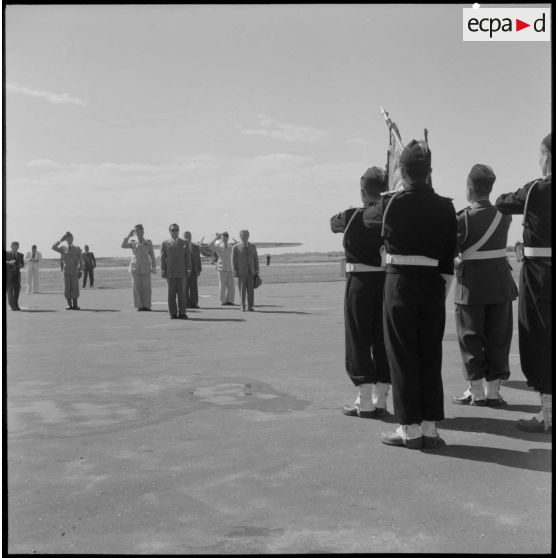 Le chef de l'état vietnamien Bao Daï rend honneur au drapeau pendant que l'hymne vietnamien est joué sur le terrain d'aviation d' Hanoï.