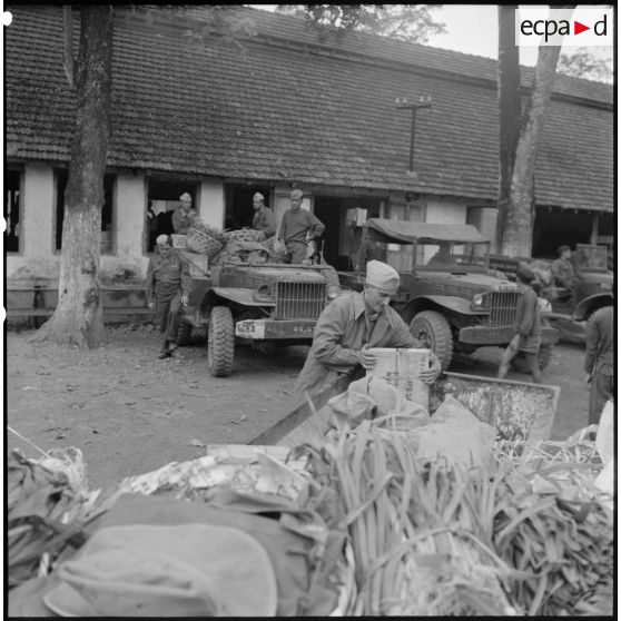 Chargement de légumes, de caisses et de sacs de vivres sur des camions, destinés à ravitailler les troupes au Tonkin.