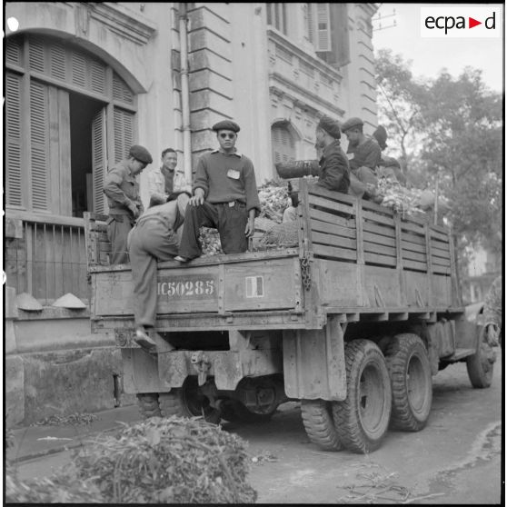 Chargement de légumes, de caisses et de sacs de vivres sur des camions, destinés à ravitailler les troupes au Tonkin.