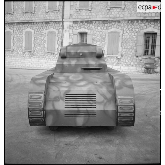 Présentation de face d'une maquette de char montée sur une Peugeot 402 dans le parc d'artillerie de Marseille.