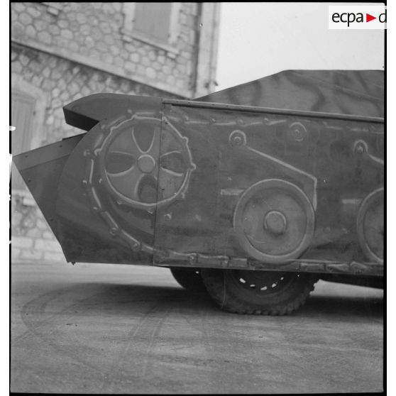 Vue latérale arrière droite d'une maquette de char montée sur une Peugeot 402 dans le parc d'artillerie de Marseille.