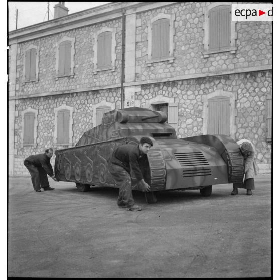 Premier temps de l'enlèvement d'une maquette de char montée sur une Peugeot 402, dans le parc d'artillerie de Marseille.