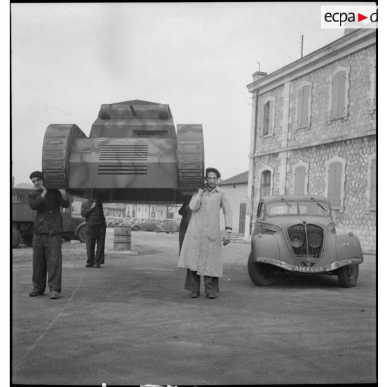 Troisième temps de l'enlèvement d'une maquette de char montée sur une Peugeot 402, dans le parc d'artillerie de Marseille.