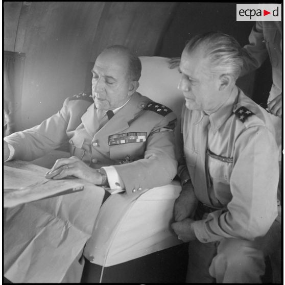 Le général de Lattre de Tassigny, commandant en chef en Indochine et le général Salan étudient des documents dans l'avion qui les mène au Tonkin.