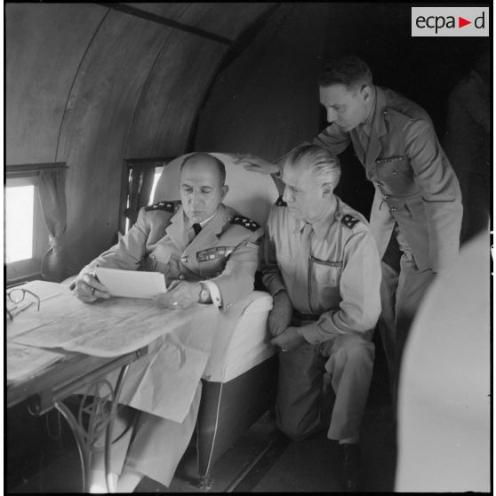 Le général de Lattre de Tassigny, commandant en chef en Indochine et le général Salan étudient des documents dans l'avion qui les mène au Tonkin.