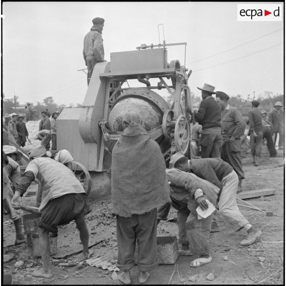 Utilisation d'une bétonnière sur le chantier de construction d'un blockhaus dans le delta du Tonkin.