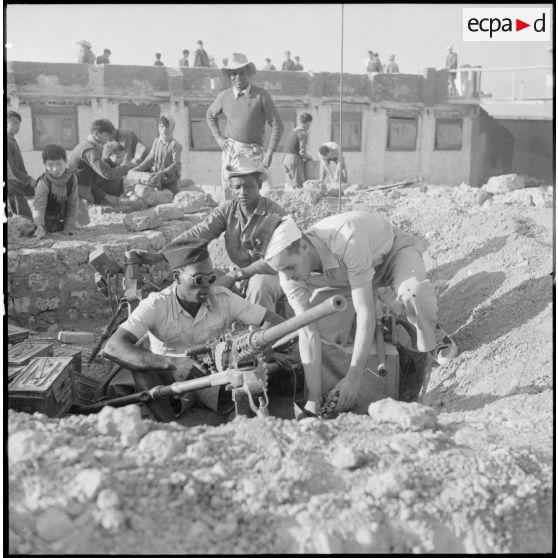 Le sergent Deurwiller, chef de poste, vérifie une mitrailleuse lourde Browning M2 de 12,7 mm après l'attaque Viêt-minh du poste de Huu Bang.