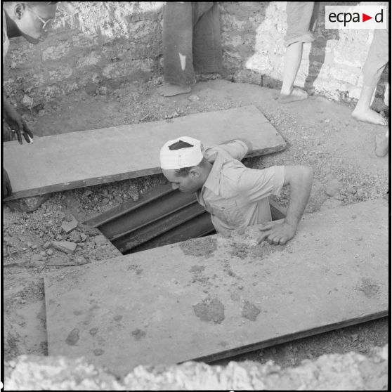 Le sergent Deurwiller, ched de poste, à l'entrée du souterrain dans lequel les hommes du poste de Huu Bang trouvèrent refuge pendant l'attaque viêt-minh du 28 décembre 1950.