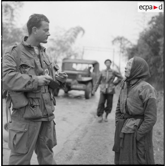 Sur la route entre Sontay et Trung Ha, une paysanne vietnamienne qui s'était cachée pendant les combats donne des renseignements à un soldat.