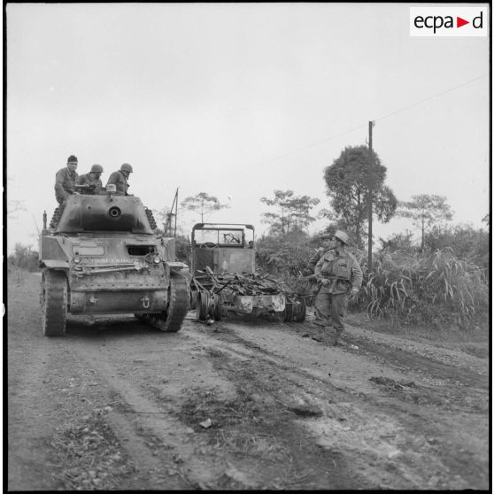 Sur la route de Son Tay et Trung Ha, une colonne de secours composée de blindés et de fantassins progresse lentement croisant sur la route des véhicules détruits.