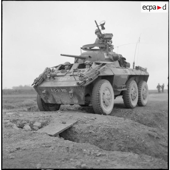 Une automitrailleuse M8 light Armored car est ralentie dans sa progression par une coupure le long de la route entre Sontay et Trung Ha.