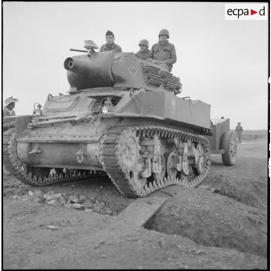 Un char léger M8 obusier (Howitser) de soutien direct est ralenti  dans sa progression par une coupure de route le long de la route entre Sontaay et Trung Ha.