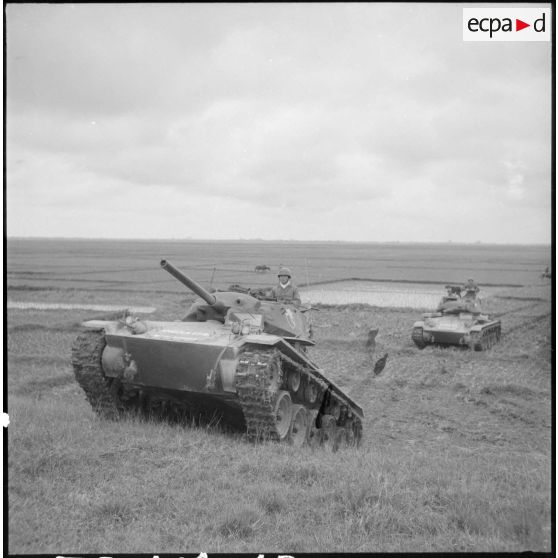 Progression de chars M24 Chaffee du 1er régiment de chasseurs à cheval à travers champs et rizières, sous la protection de fantassins.
