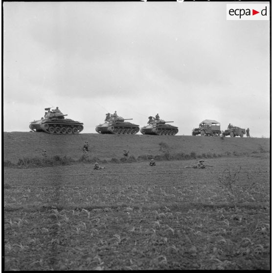 Un convoi de blindés du 1er régiment de chasseurs à cheval stoppé par des coupures de routes au Tonkin et immédiatement mis en batterie sous la protection des éléments à pied débarqués.