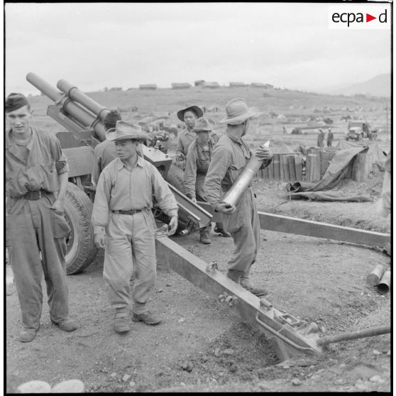 Les artilleurs du régiment d'artillerie coloniale du Maroc (RACM) préparent les charges d'un obusier M2A1 de calibre 105 mm sur un point d'appui au Tonkin.