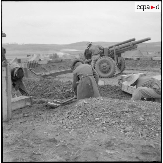 Mise en place d'un obusier M2A1 de calibre 105 mm par des artilleurs du régiment d'artillerie coloniale du Maroc (RACM) sur un point d'appui au Tonkin.