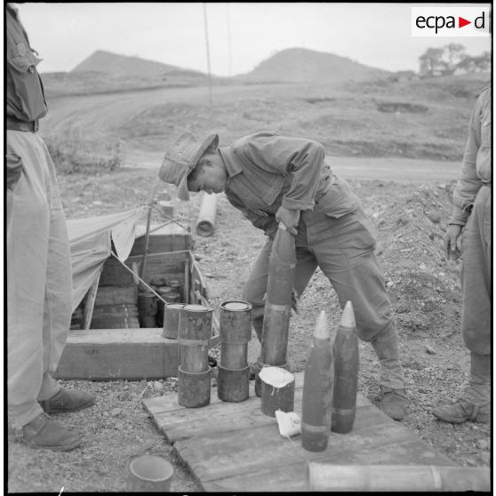 Les artilleurs du régiment d'artillerie coloniale du Maroc (RACM) préparent les charges d'un obusier M2A1 de calibre 105 mm sur un point d'appui au Tonkin.