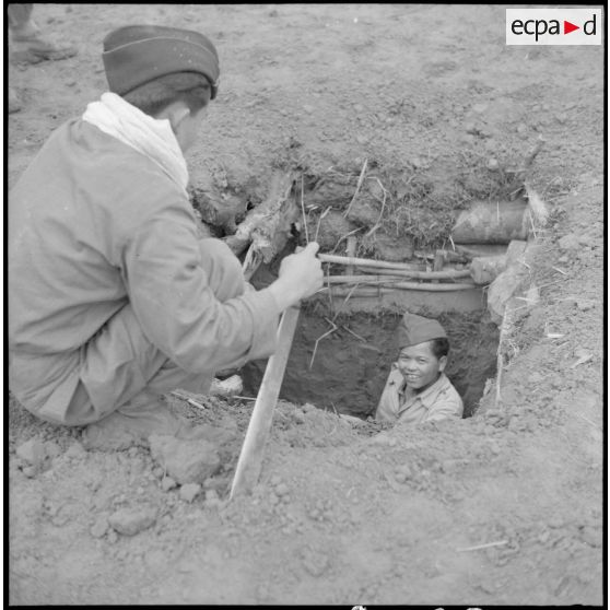 Deux soldats de la 9e compagnie du 3e bataillon du 21e régiment d'infanterie coloniale (3/21e RIC) plaisantent au cours d'un moment de pause sur le point d'appui du col des Ananas.