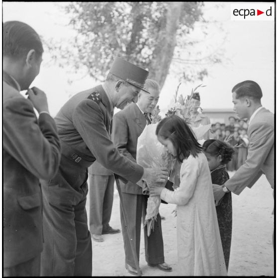 Deux petites filles vietnamiennes souhaitent la bienvenue au  général de Lattre de Tassigny et au président du Vietnam Tran Van Huu lors d'une visite à Bac Ninh.